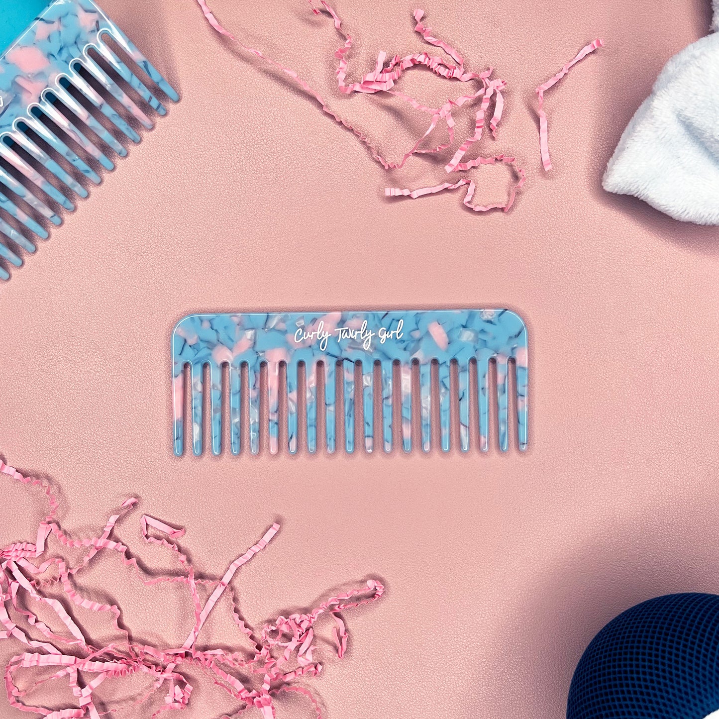Blue wide tooth comb on pink table