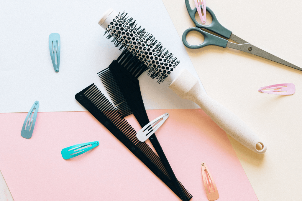 Comb and hair brush, with scissors and clips on a table