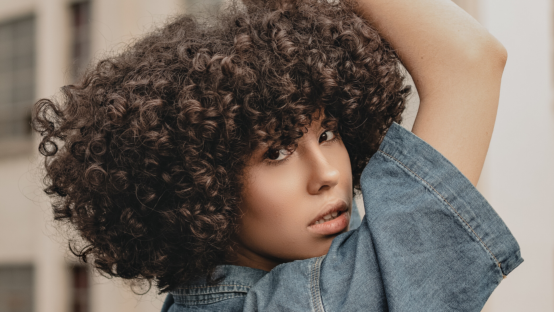 Girl with short curly hair and denim top