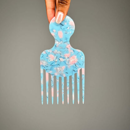 Hand holding blue afro hair comb