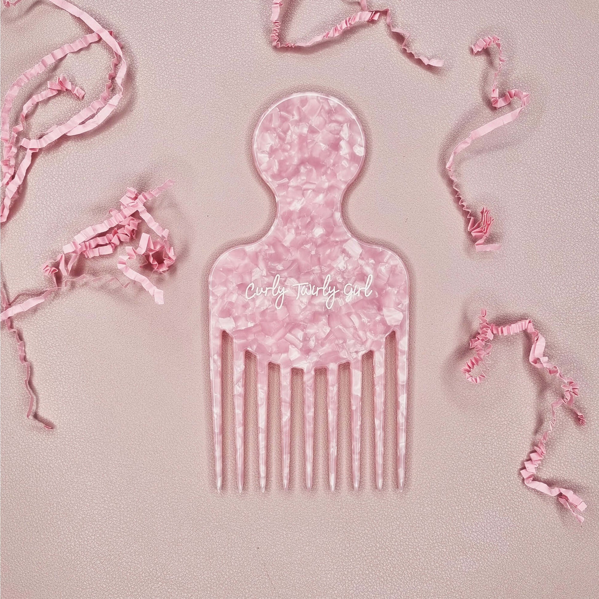Pink afro hair comb on pink table